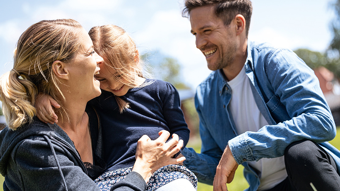 Junge Familie mit Kind im Arm.
