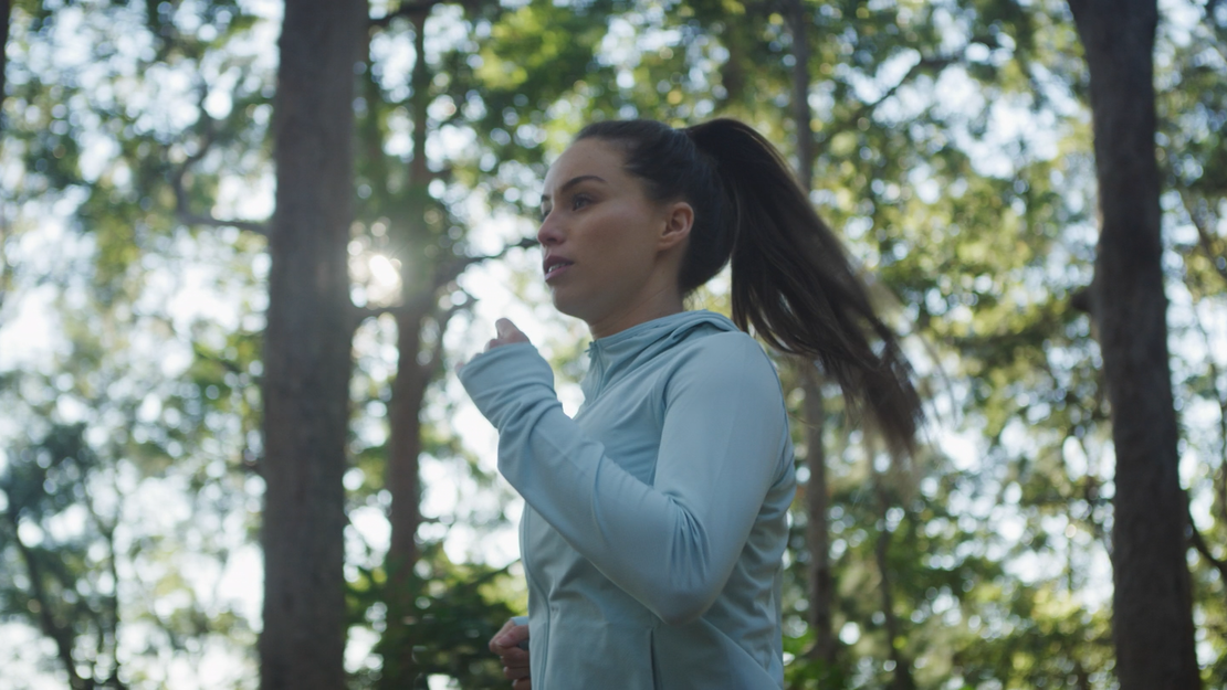 Junge Frau joggt im Wald.
