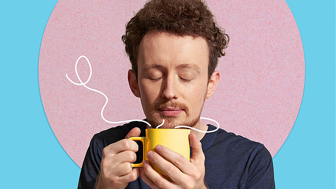 Mann mit geschlossenen Augen hat eine dampfende Tasse in der Hand